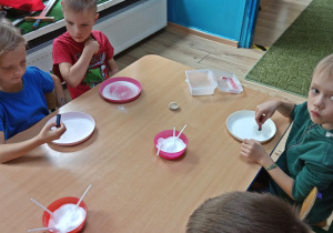 Dzieci wylewają barwnik na talerz